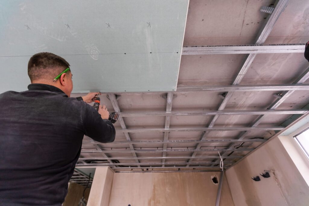 Operaio edile realizza soffitto in cartongesso