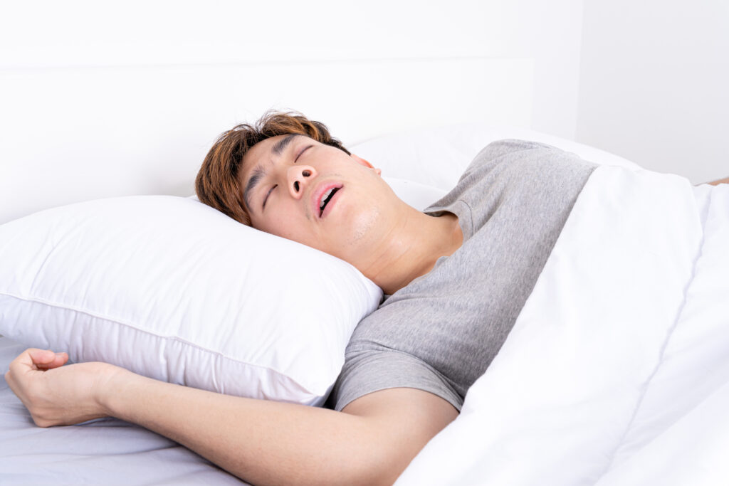 Uomo dorme nel letto con la testa sul cuscino