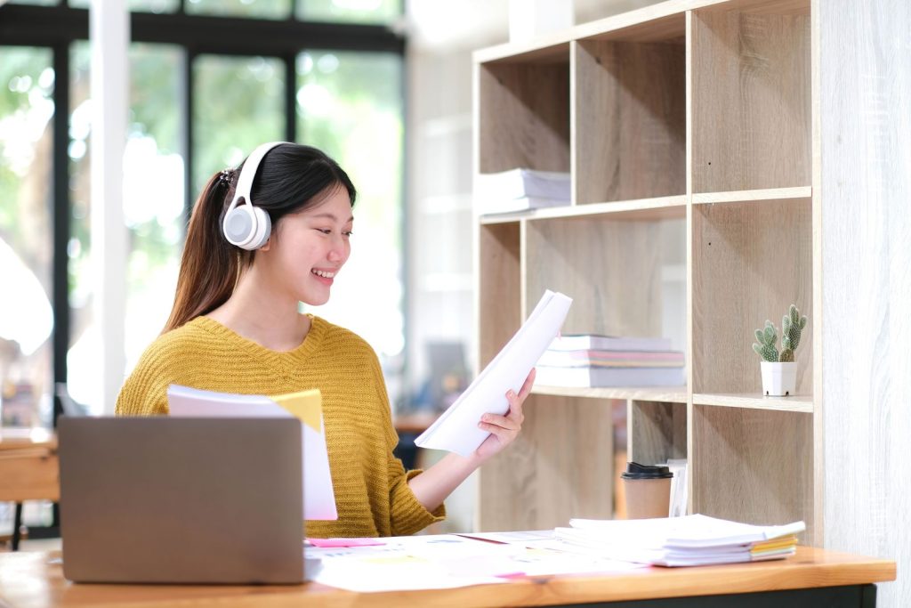 Studentessa alla scrivania con pc e fogli di carta